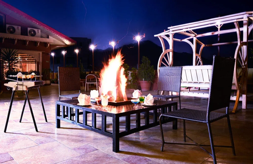 An open fire burning beside a gazebo on Jannat Terrace after dark